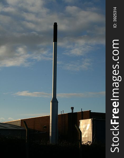Factory chimney against a dramatic sky. Factory chimney against a dramatic sky