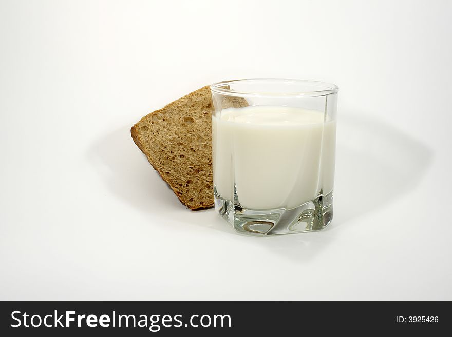 Rye-bread and glass of milk on white background. Rye-bread and glass of milk on white background