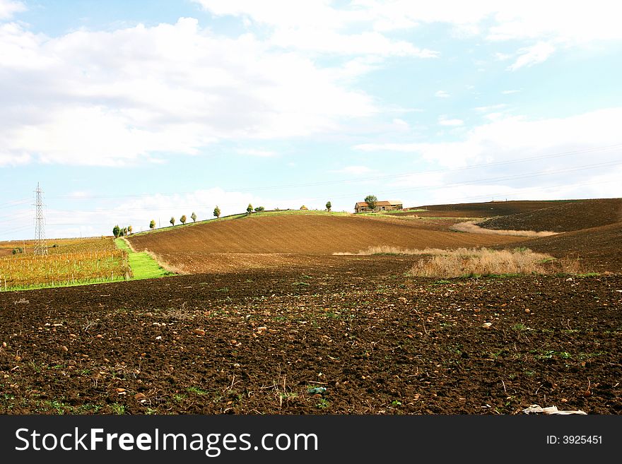 Beautiful autumn country landscape.  cultivated land, hill with a way for the farm and blue sky & clouds. Sicily, Italy. Beautiful autumn country landscape.  cultivated land, hill with a way for the farm and blue sky & clouds. Sicily, Italy