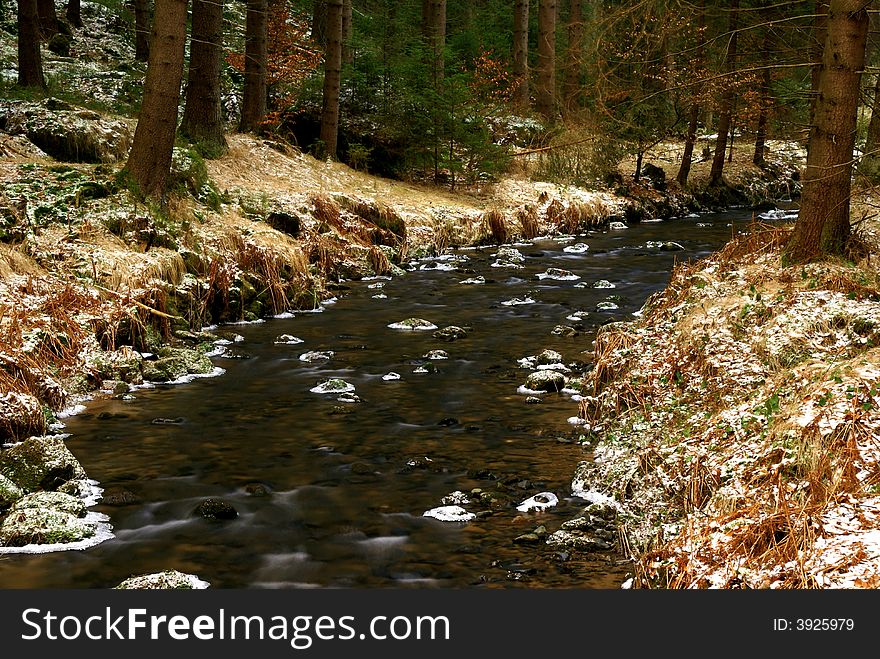 Landscape with motion blurred river and partly snow covered forest. Landscape with motion blurred river and partly snow covered forest.