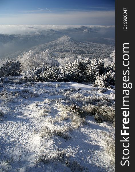 Winter inversion and low lying clouds in snow covered hilly country.