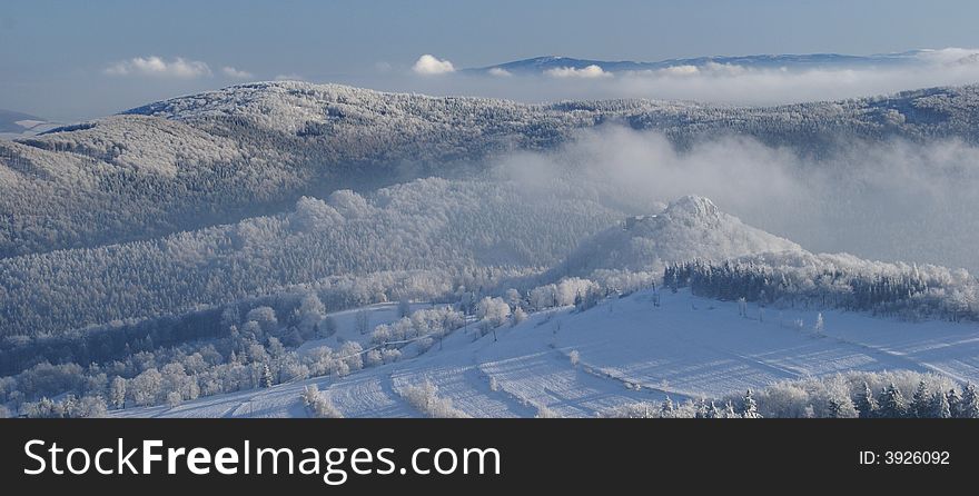 Winter inversion and low lying clouds in snow covered hilly country.