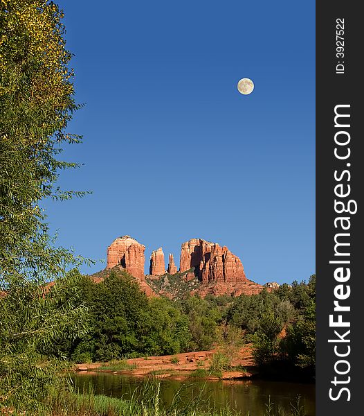 View of Cathedral Rocks in Sedona with a rising moon in the sky. View of Cathedral Rocks in Sedona with a rising moon in the sky