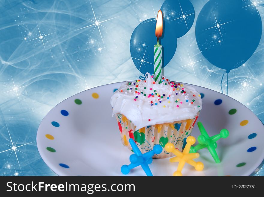 Birthday cupcake on fun plate with toy jacks and balloons. Birthday cupcake on fun plate with toy jacks and balloons.