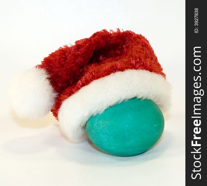 Green-blue egg with red Santa hat. Green-blue egg with red Santa hat.