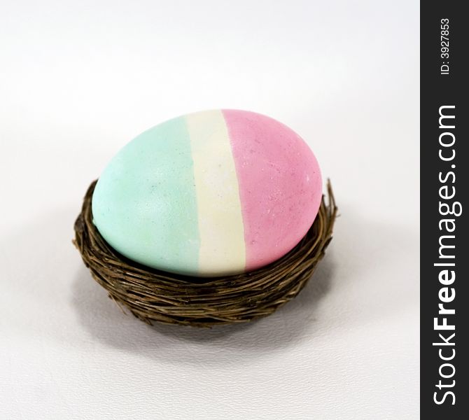 Tri-colored striped Easter egg in a nest.