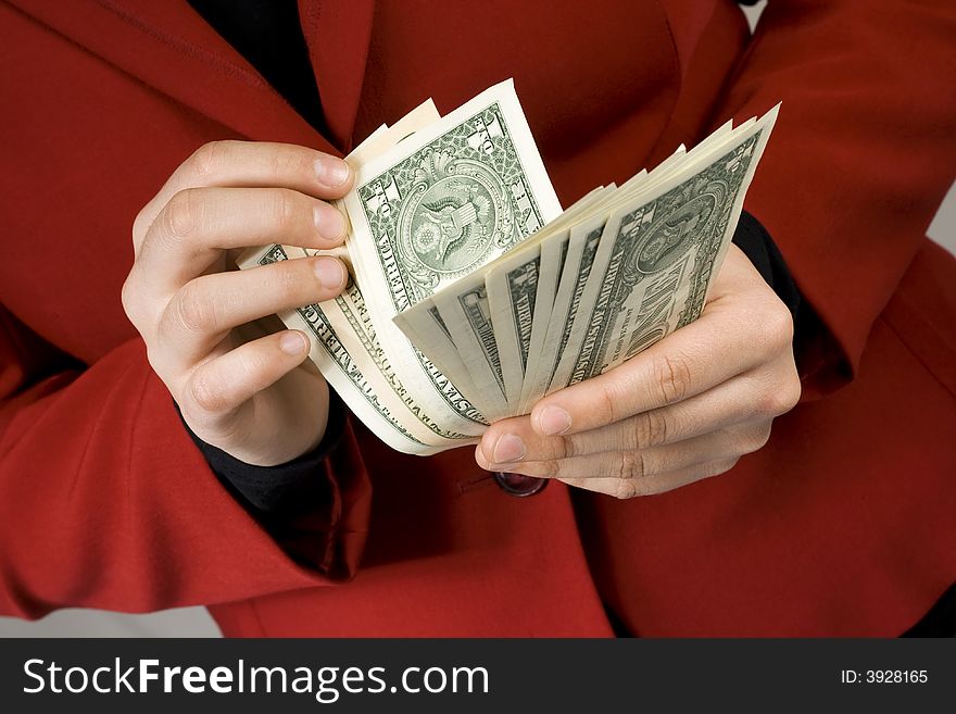 Close-up of hands counting Dollars. Red dress in background. Studio shot. Close-up of hands counting Dollars. Red dress in background. Studio shot.