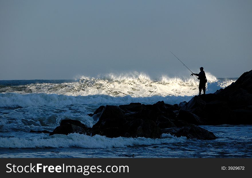 Fisherman Silhouette On Rocks