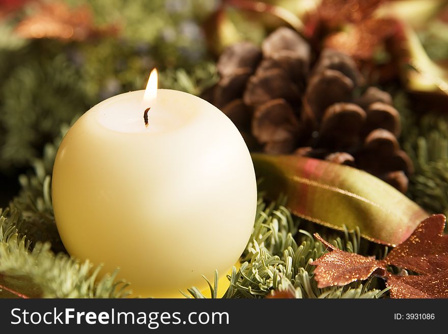 Close up of a christmas chaplet with a burning candle