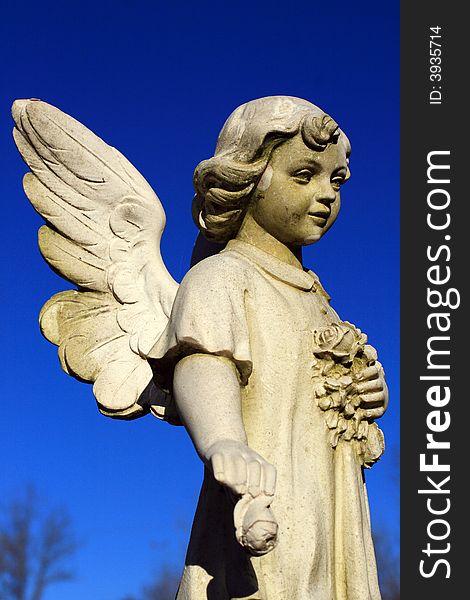 Old weathered statue stands guard at a cemetery. Old weathered statue stands guard at a cemetery