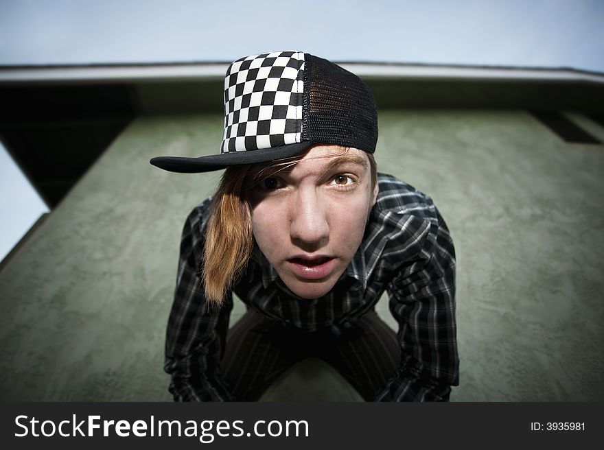 Wide angle shot of a teenage in front of a green stucco wall shot with a flash. Wide angle shot of a teenage in front of a green stucco wall shot with a flash