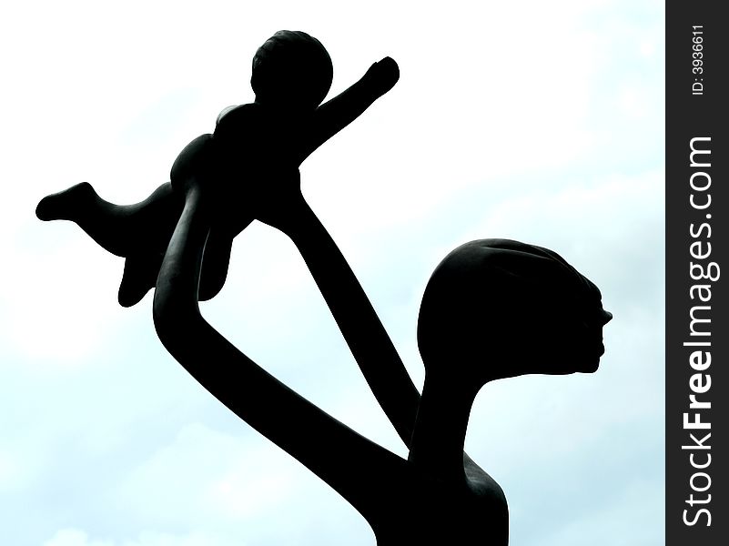 Silhouette of statue of a mother and her child.