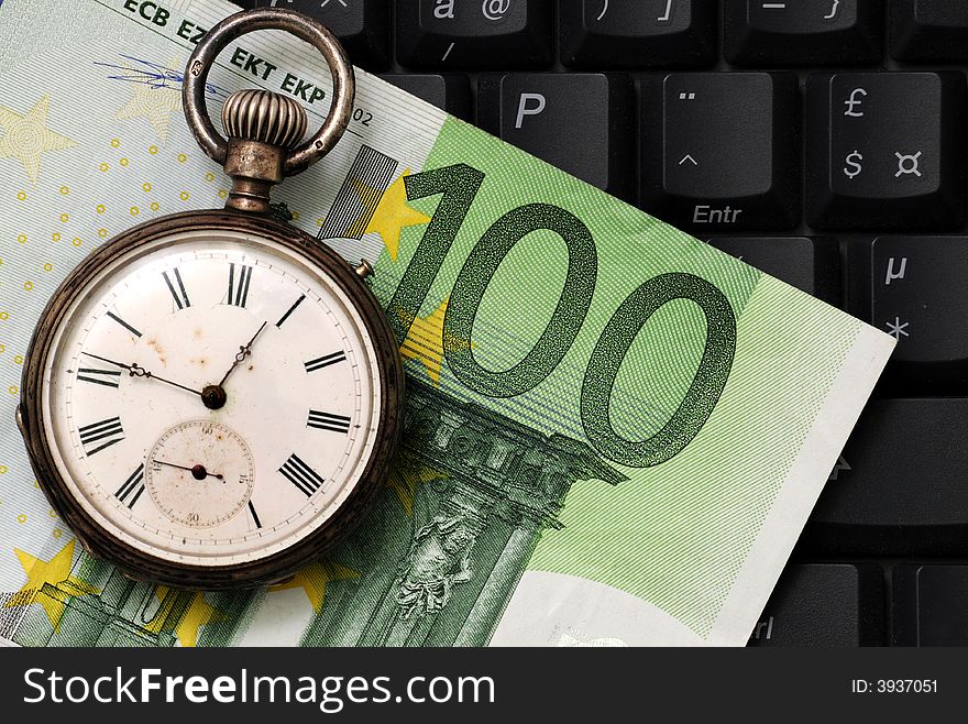 A view with a watch, banknote and coins over a black keyboard. A view with a watch, banknote and coins over a black keyboard