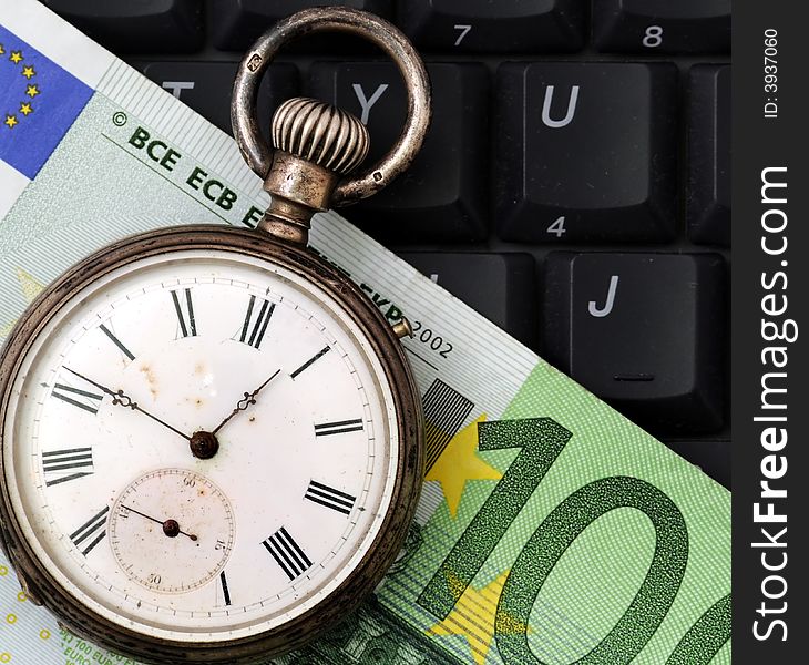 A view with a watch, banknote over a black keyboard. A view with a watch, banknote over a black keyboard