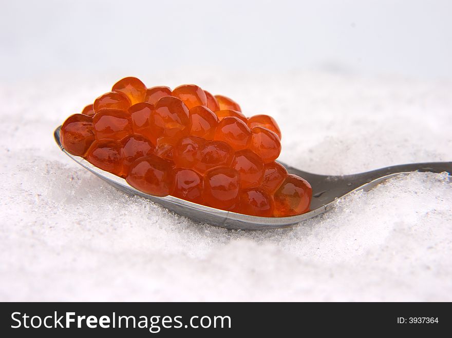 Red caviar in the spoon, on a snow. Red caviar in the spoon, on a snow