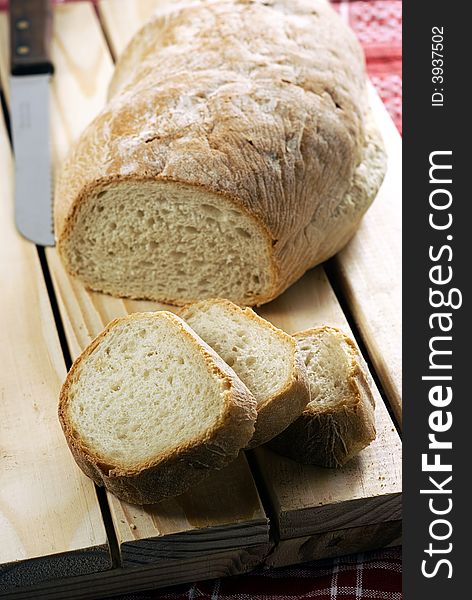 A composition with traditional tuscan bread sliced upon a breadboard