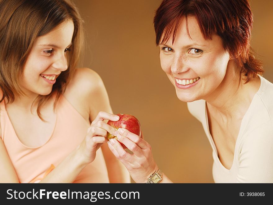 A mother and her daughter with apple. A mother and her daughter with apple