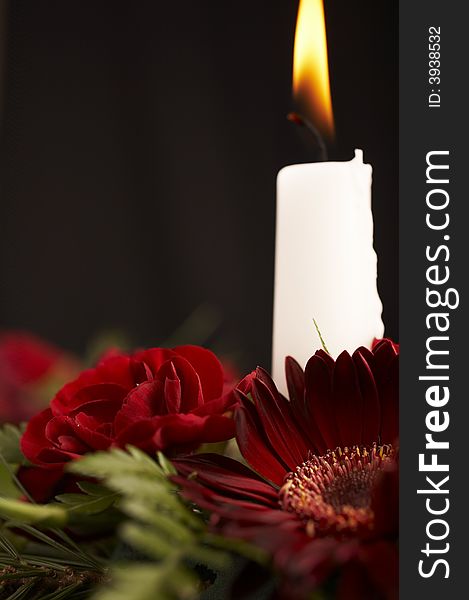 Candles with flower setup on the brown table over black background