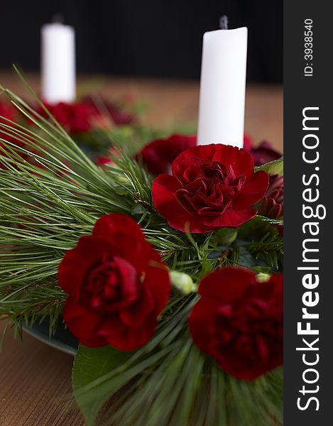 Candles with flower setup on the brown table over black background