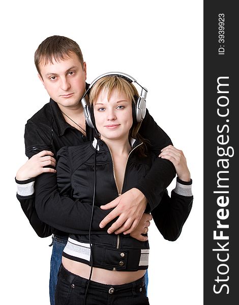 Young happy amorous couple with headphones at home
