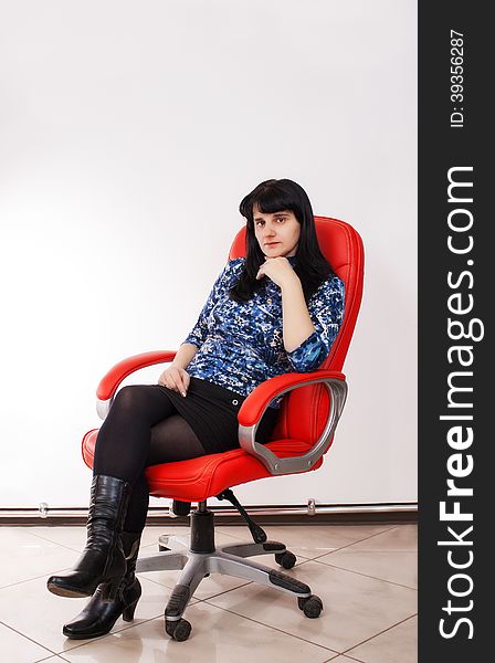 Young Beautiful Woman Posing Sitting On A Red Chair