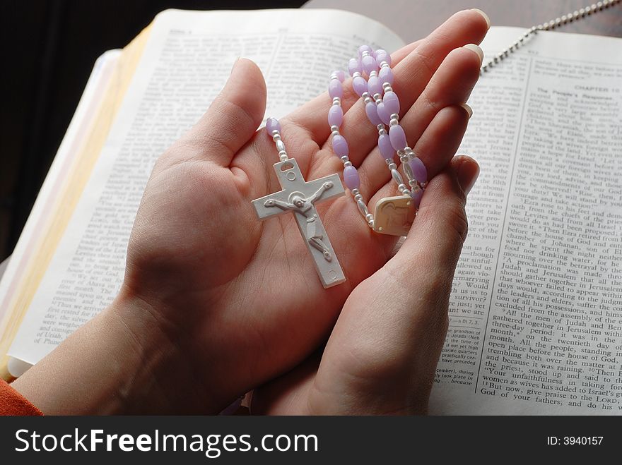 Holy bible open with a cross on a hand. Holy bible open with a cross on a hand