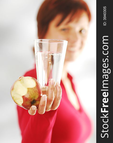 A woman with glass of water and apple. A woman with glass of water and apple