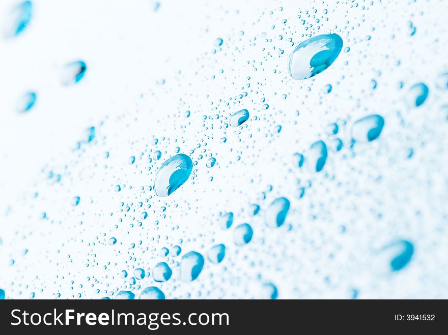 Blue droplets on a white background. The top left corner and bottom right corner are out of focus