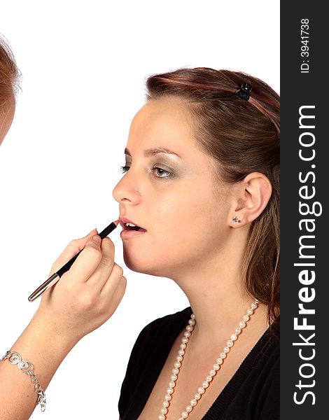 Makeup artist applying lipstick to models lips