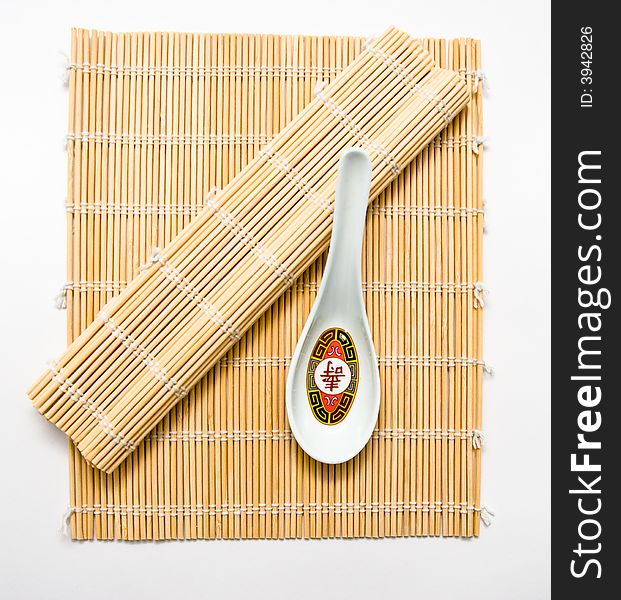 A soup spoon on bamboo used for rolling sushi.