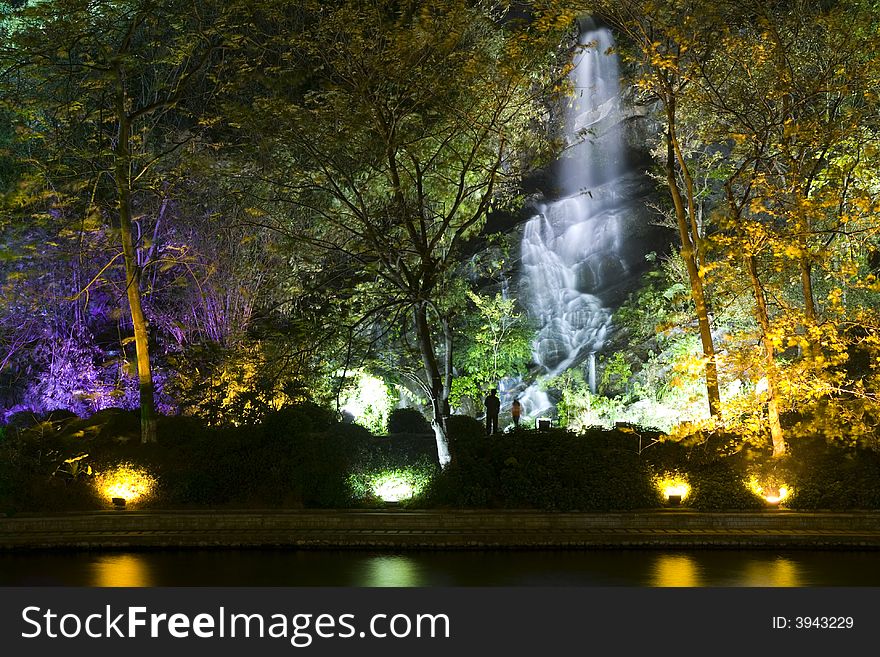 Colourful lights lighting up a waterfall at night. Colourful lights lighting up a waterfall at night