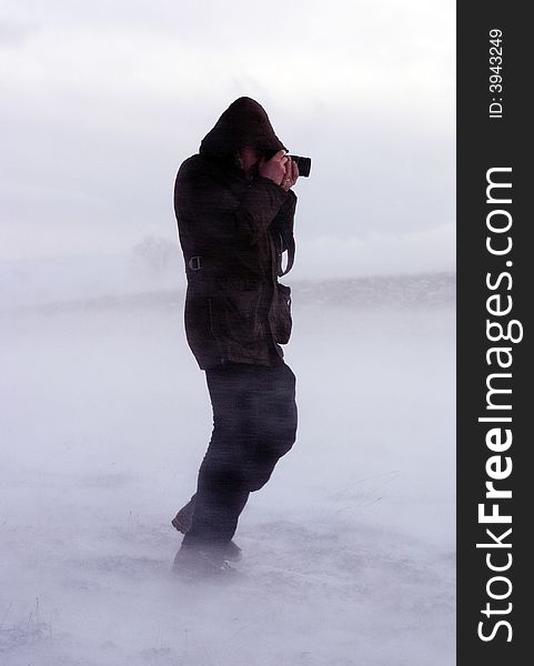 Photographer in the now storm with its camera. Photographer in the now storm with its camera