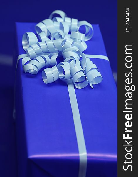 A present wrapped in blue wrapping paper and ribbon. A present wrapped in blue wrapping paper and ribbon