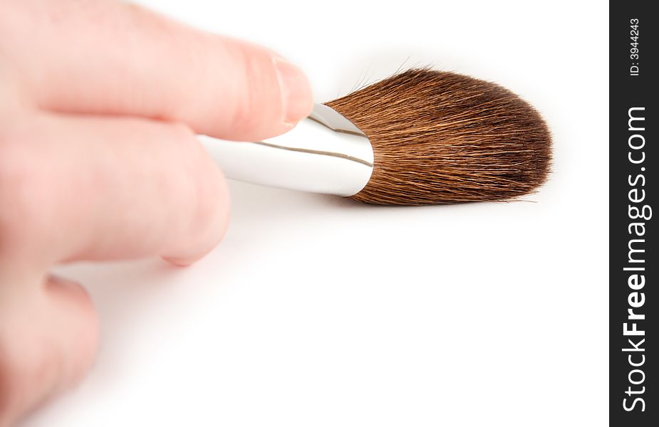 Hand holding a cosmetics brush. Hand holding a cosmetics brush