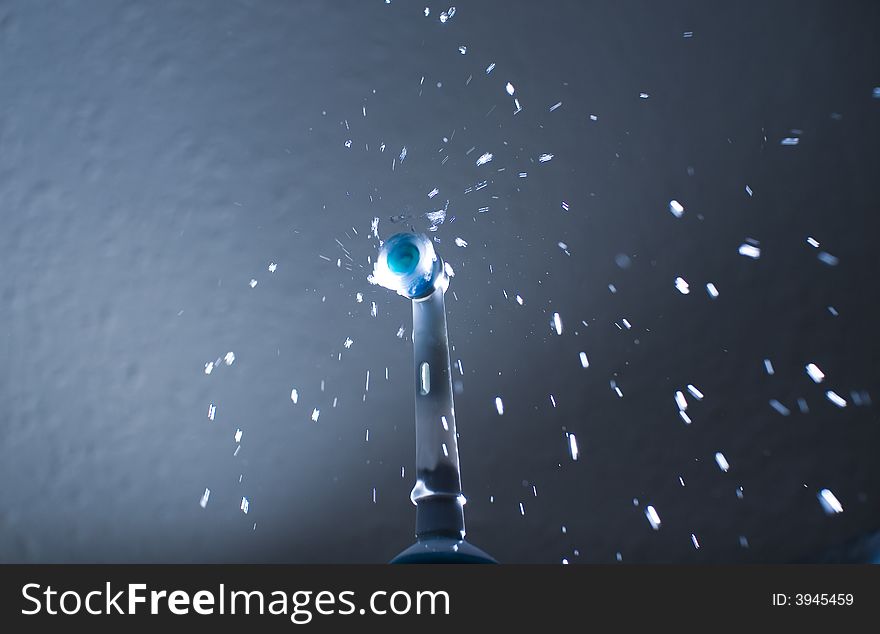 Electric toothbrush turned on and spraying water