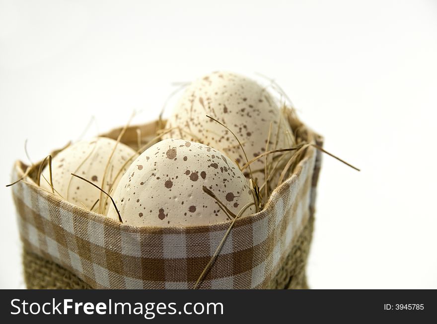 Natural easter eggs in basket on white background