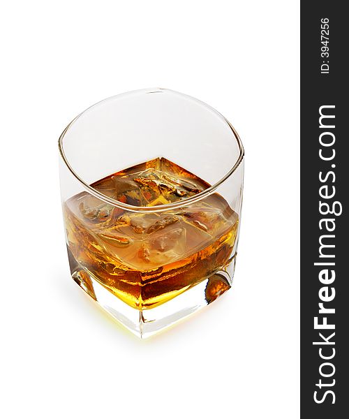 Whiskey on the rocks in a tetrahedral glass. Object over white. Whiskey on the rocks in a tetrahedral glass. Object over white.