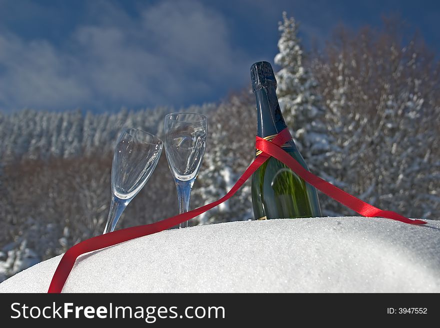 Glasses and bottle of champagne in snow