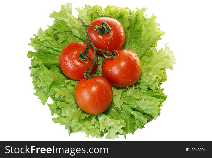 Tomatoes on leaves of salad isolated on a white background