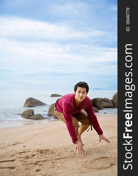 A man running half squat on the beach. A man running half squat on the beach