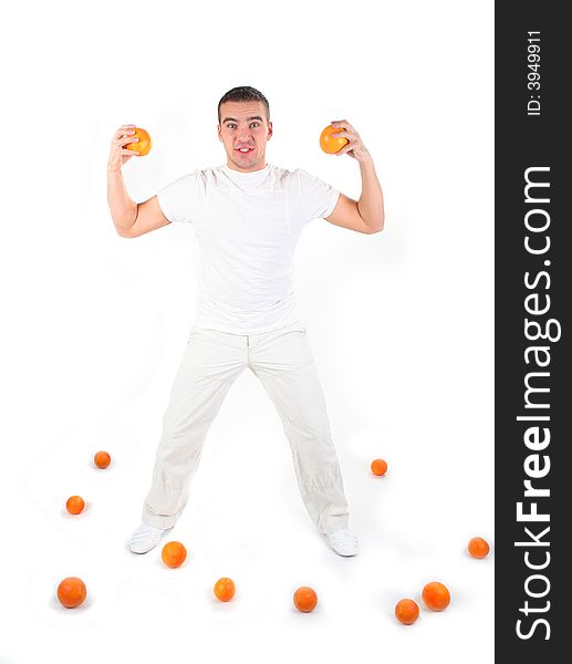 Athletic guy plaing with oranges in studio