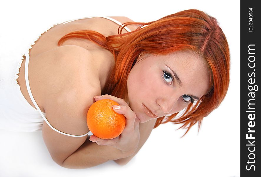 Portrait of redhead girl with orange in studio