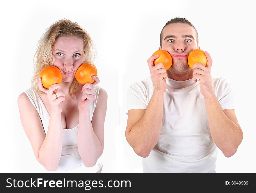 Boy and girl is playing with oranges in studio. Boy and girl is playing with oranges in studio