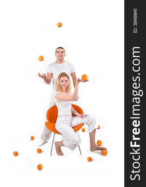 Boy and girl is playing with oranges in studio