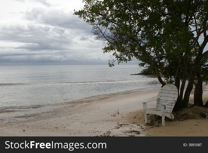 A lone chair waits for a vistor on a deserted beach. A lone chair waits for a vistor on a deserted beach