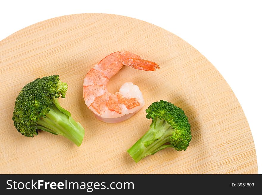 A Shrimp and two Broccoli florets on an environmentally friendly bamboo plate. A Shrimp and two Broccoli florets on an environmentally friendly bamboo plate