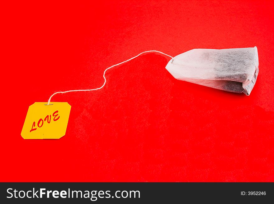 Tea-bag on a red background with sign - LOVE. Tea-bag on a red background with sign - LOVE