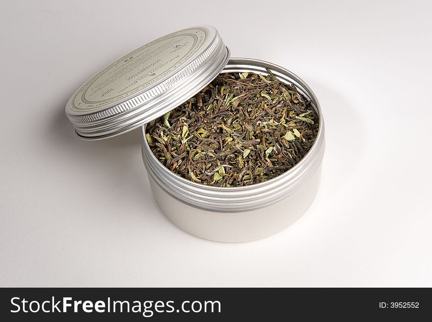 Loose Tea leaves in tin on white background photographed in studio