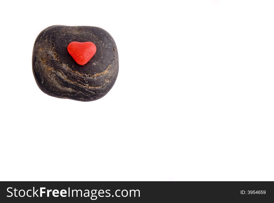 Red Candy Heart on a black stone on white background. Red Candy Heart on a black stone on white background