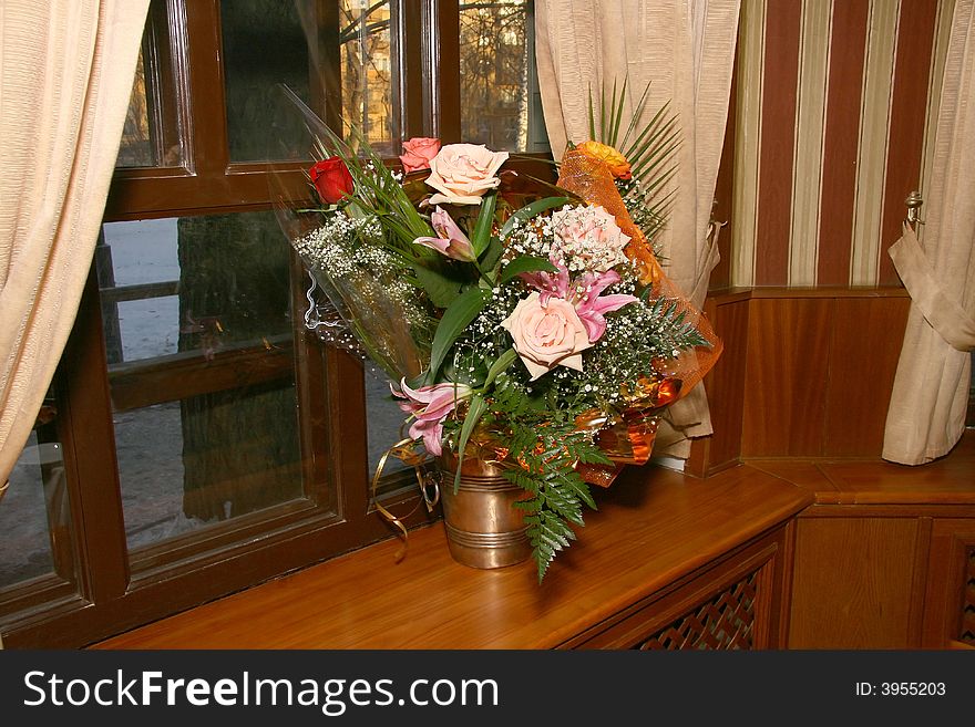 Bouquet with roses in a room on a window sill. Bouquet with roses in a room on a window sill.